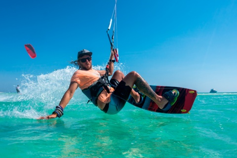 Persona che pratica kitesurf in acque cristalline