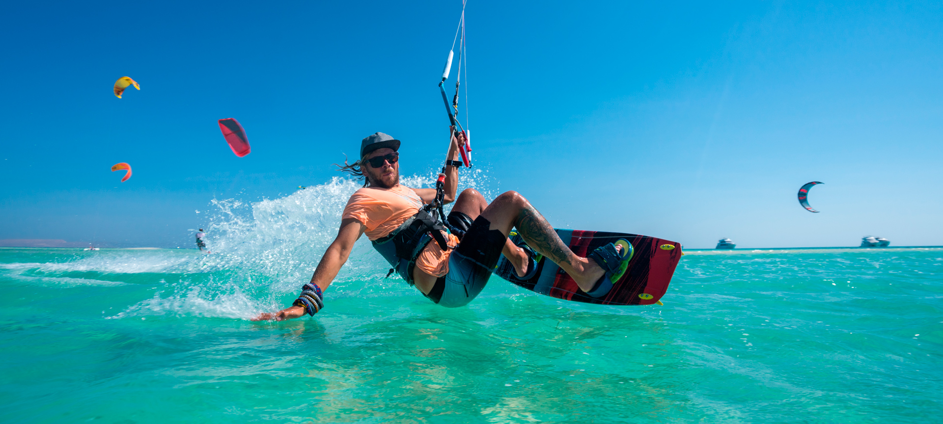 Jovem praticando kite em águas cristalinas Jovem praticando kite em águas cristalinas
