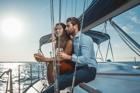 Pärchen genießt ein Glas Wein auf einem Segelboot bei Menorca, Balearen.