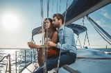 Casal saboreando uma taça de vinho em um veleiro em Menorca, Ilhas Baleares.