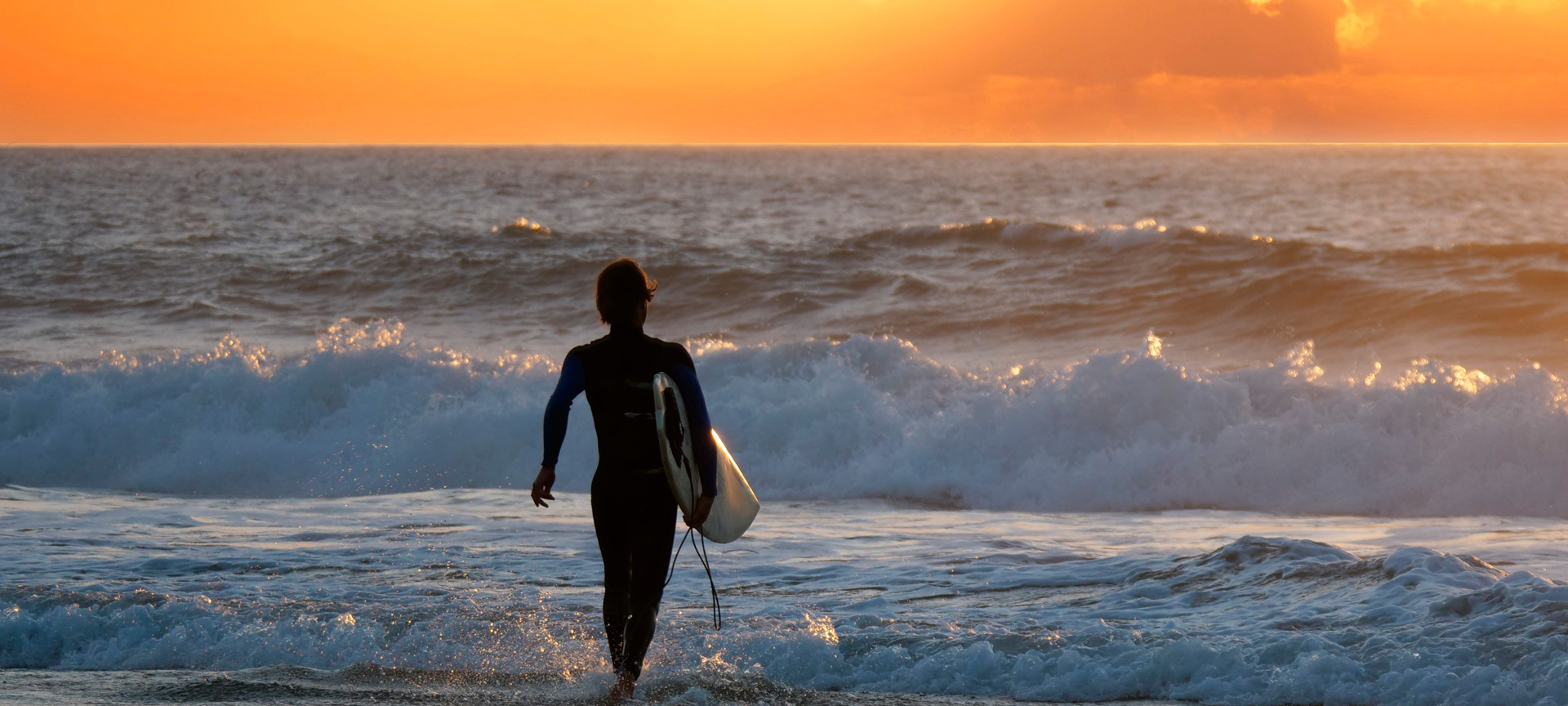 Surfista contemplando el atardecer en Fuerteventura en las Islas Canarias