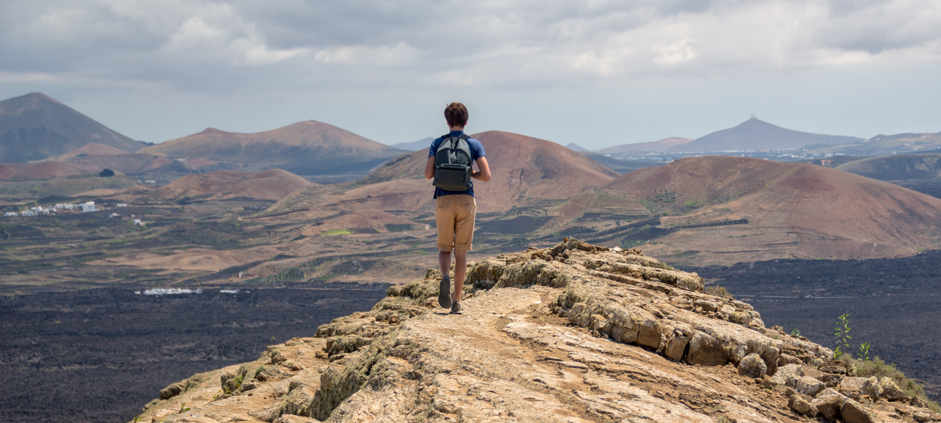Tourist walking on route to Caldera Blanca in Lanzarote, Canary Islands Tourist walking on route to Caldera Blanca in Lanzarote, Canary Islands