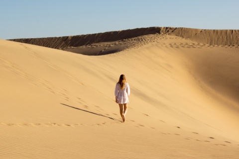 Turista en la Reserva Natural Especial de las Dunas de Maspalomas en Gran Canaria, Islas Canarias