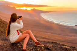 Une fille prend des photos sur la plage de Cofete, Fuerteventura