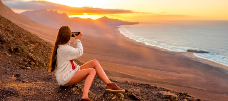 Turista mentre scatta una foto della spiaggia Cofete a Fuerteventura nelle isole Canarie
