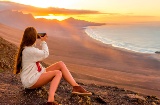 Une jeune fille prend des photos sur la plage de Cofete, Fuerteventura