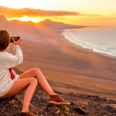 Junge Frau macht Fotos am Strand von Cofete, Fuerteventura