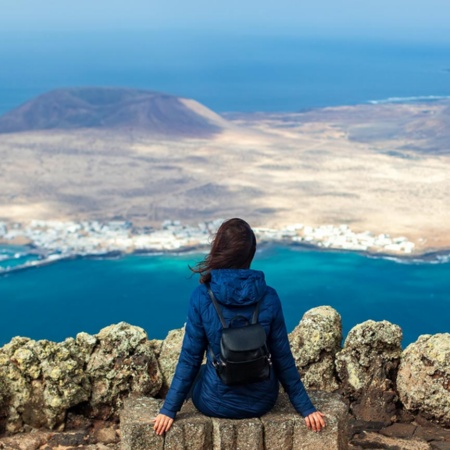 Frau, die vom Aussichtspunkt El Río aus die Landschaft betrachtet. Lanzarote