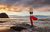 Dziewczyna ćwicząca jogę o zachodzie słońca na plaży La Tejita w Granadilla de Abona na Teneryfie, Wyspy Kanaryjskie