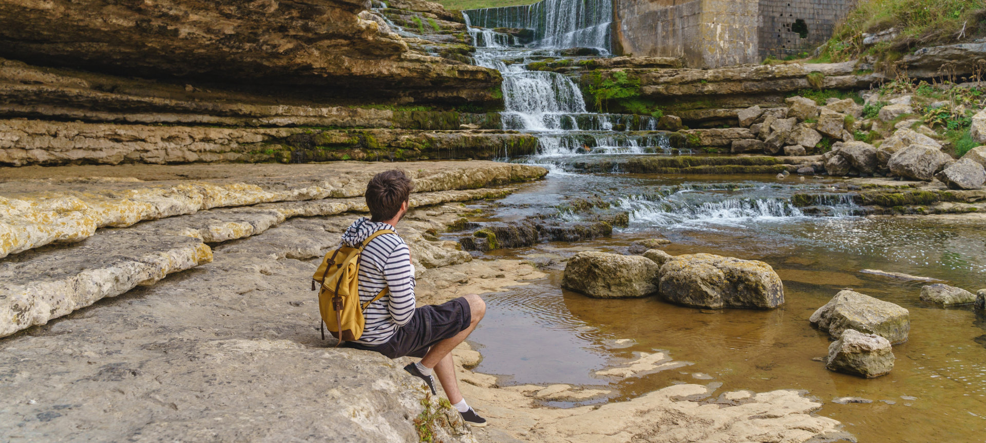 Tourist looking at the Bolao waterfall in Toñanes, Cantabria