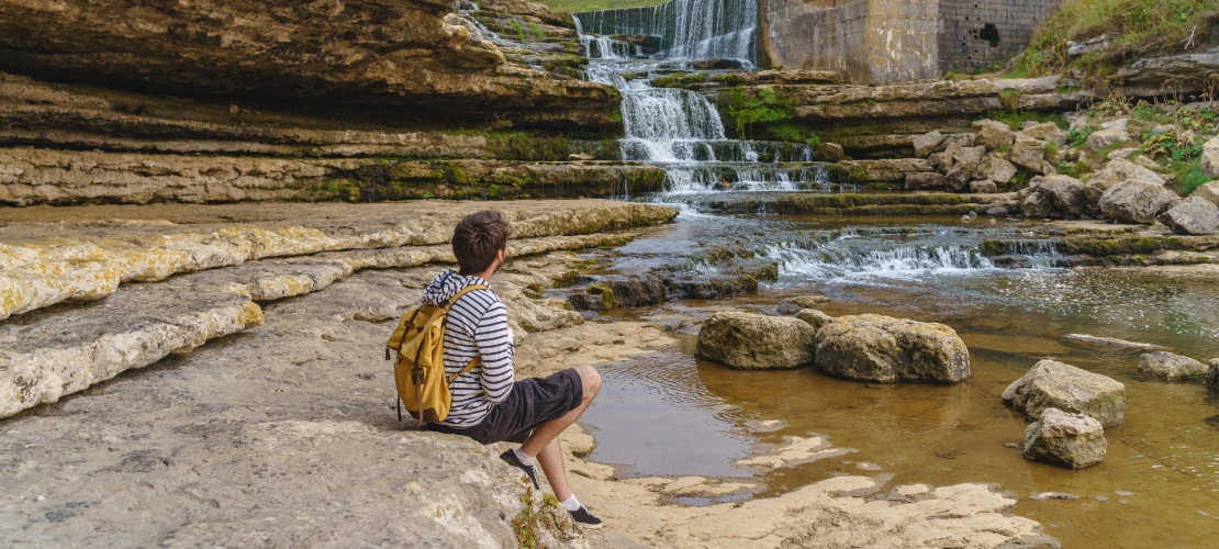 Turista contemplando a cachoeira do Bolao, em Toñanes, Cantábria