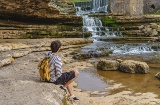 Tourist betrachtet den Bolao-Wasserfall in Toñanes, Kantabrien