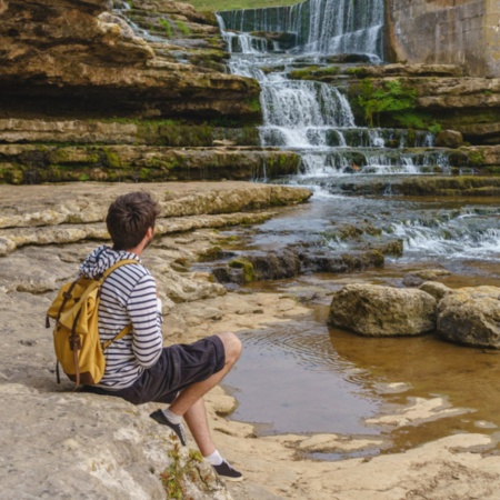 Turista contemplando a cachoeira do Bolao, em Toñanes, Cantábria