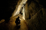 Uomo che illumina le rappresentazioni di arte rupestre nella grotta di Chufín a Riclones, Cantabria