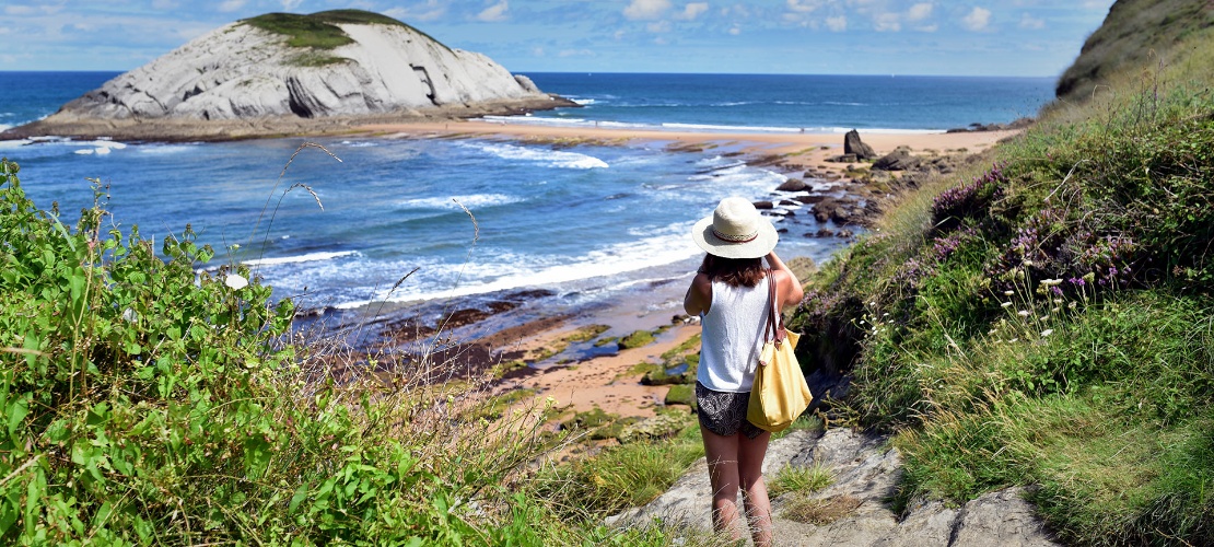 カンタブリア州リエンクレスにあるコバチョ・ビーチの写真を撮影している旅行者