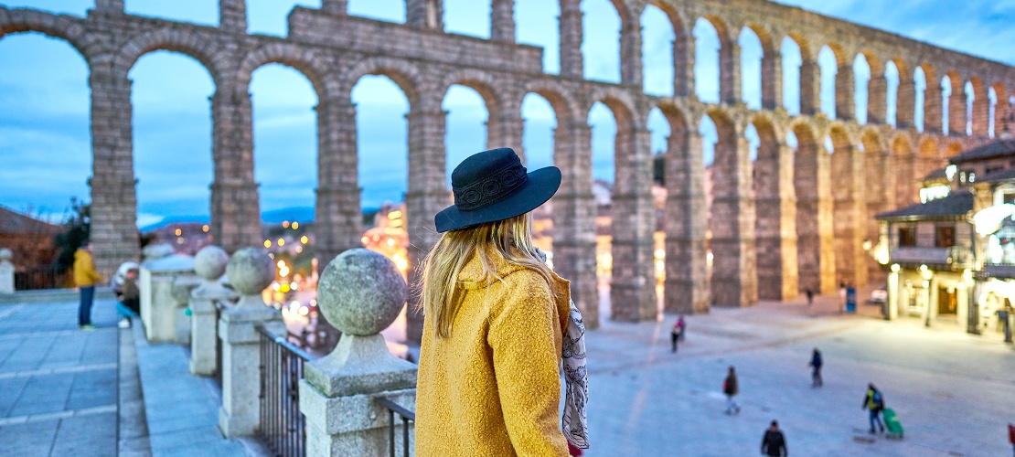 Girl looking at the Roman aqueduct of Segovia