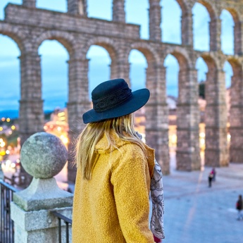 Girl looking at the Roman aqueduct of Segovia