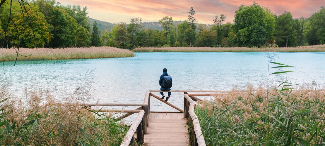 Turista che contempla la laguna di Uña, nel Parco Naturale della Serranía de Cuenca, Castiglia-La Mancia