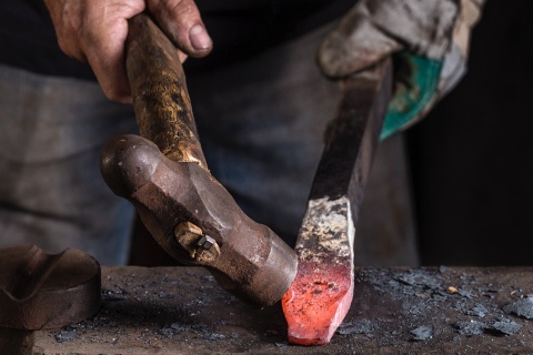 Kunsthandwerker schmiedet ein Schwert in einer Werkstatt in Toledo.