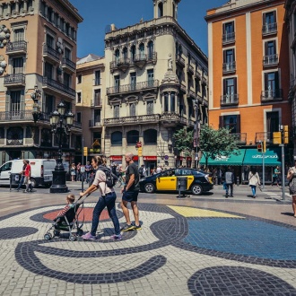 Spaziergänger neben Mirós Mosaik auf Las Ramblas. Barcelona
