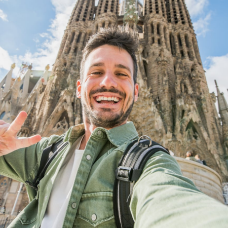 Ein Tourist macht ein Selfie an der Sagrada Familia in Barcelona, Katalonien