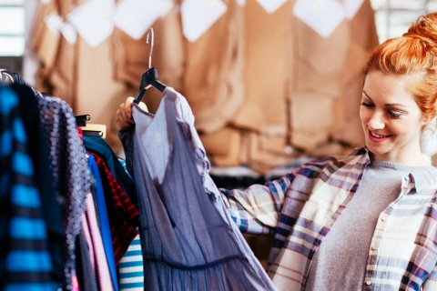 Moça fazendo compras olhando um vestido