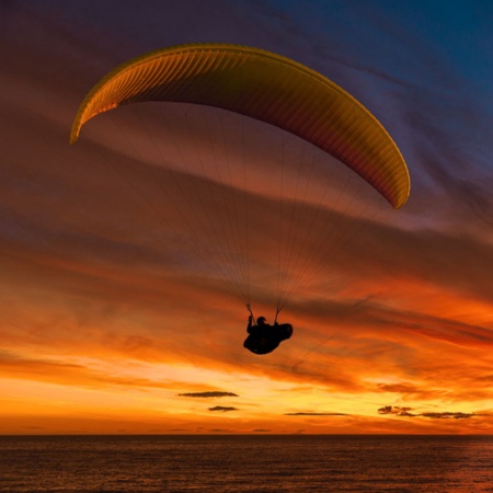 Gleitschirmfliegen bei Sonnenuntergang