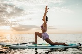 Mujer haciendo yoga en una tabla Sup