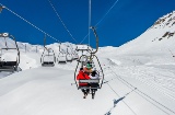 フォルミガルのスキー場でリフトに乗車中のスキーヤー