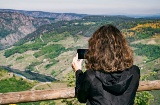 Tourist, der die Landschaft von einem Aussichtspunkt in der Ribeira Sacra fotografiert