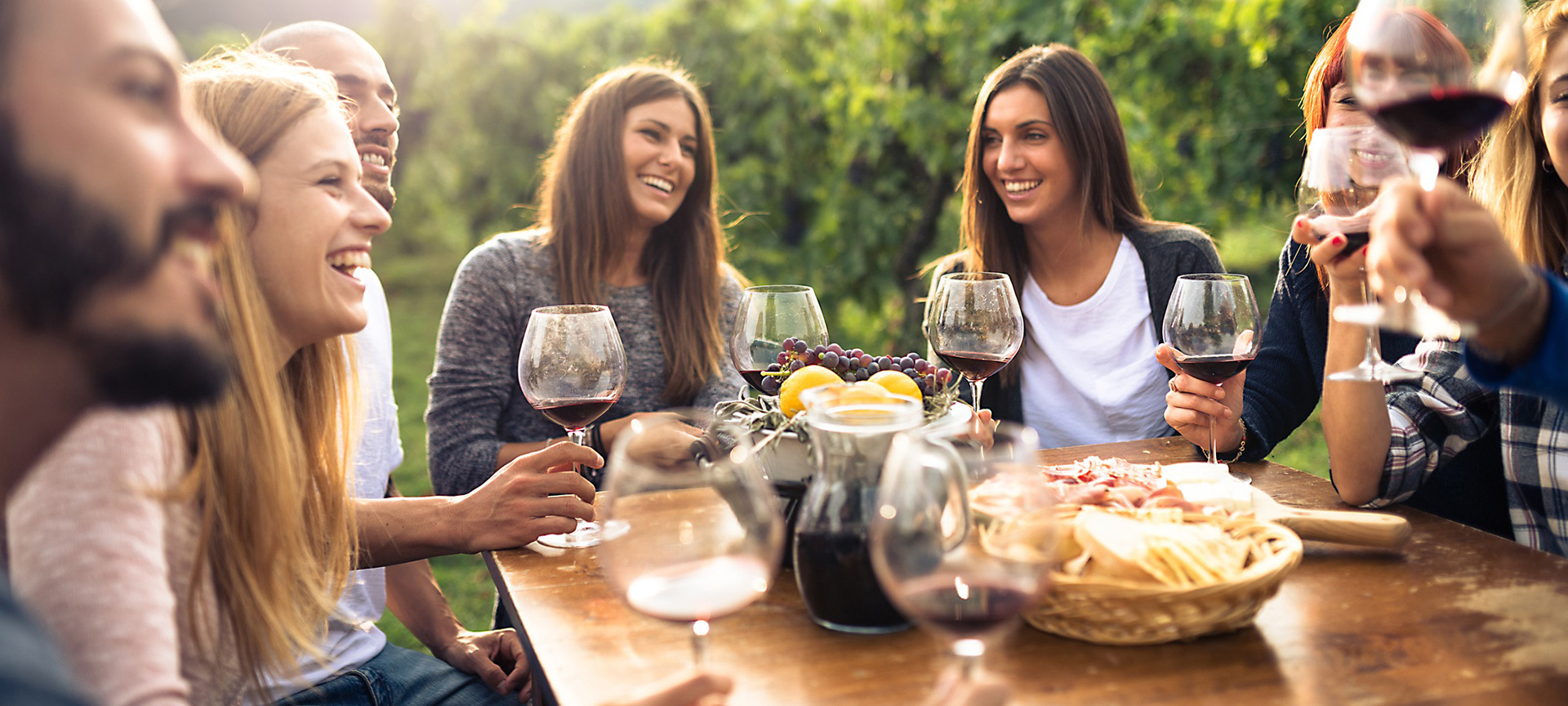 Amici mentre brindano con bicchieri di vino rosso