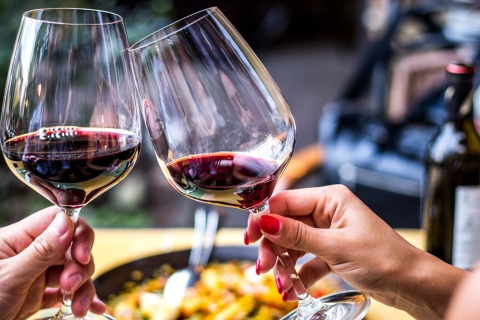 Тост с красным вином на фоне паэльи.