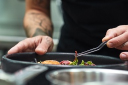 Шеф-повар сервирует блюдо