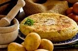 Spanish omelette with products to make it and a mortar