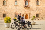 Ein Paar Radfahrer vor dem Erzbischöflichen Palast in Alcalá de Henares, Region Madrid