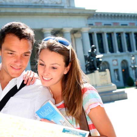 Tourists looking at a map of Madrid by the Prado Museum