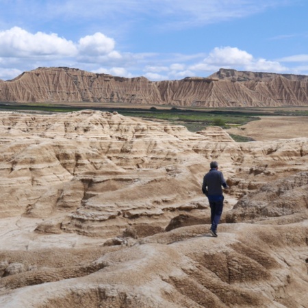 Un uomo che attraversa il Parco Naturale delle Bardenas Reales, in Navarra