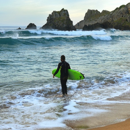 Surfista en la playa de Laga en Vizcaya, País Vasco