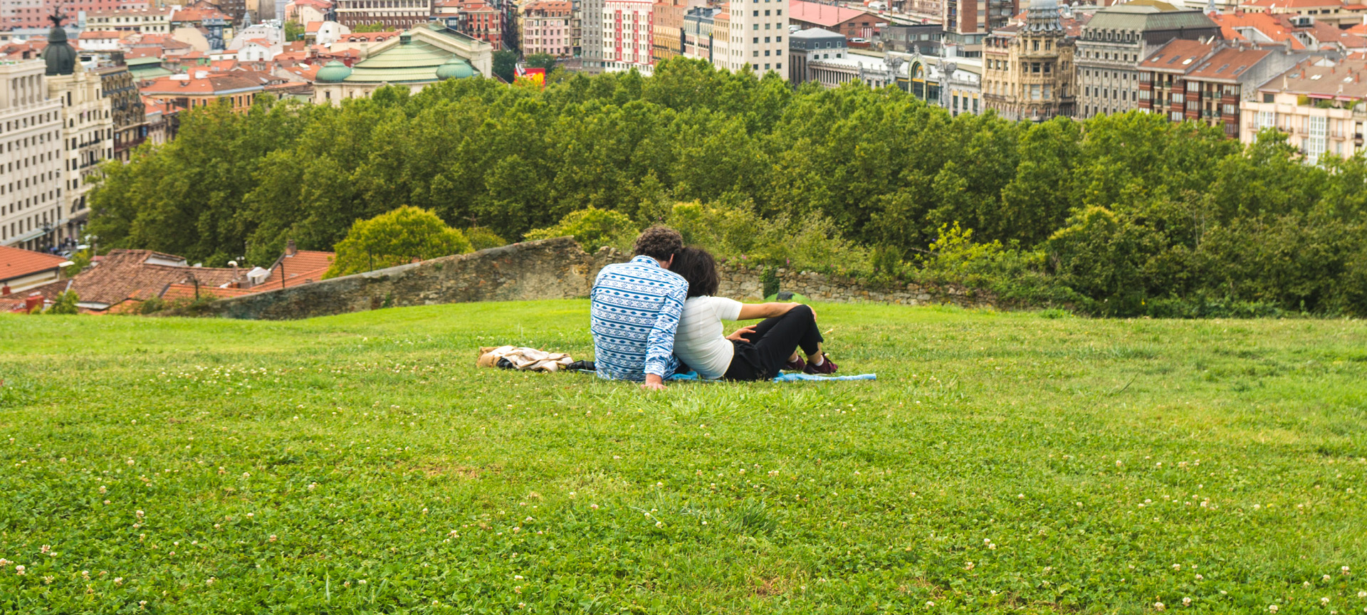 Ein Pärchen genießt den schönen Panoramablick auf Bilbao vom Park auf dem Hügel oberhalb der Altstadt