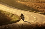 Motociclista che guida lungo una strada