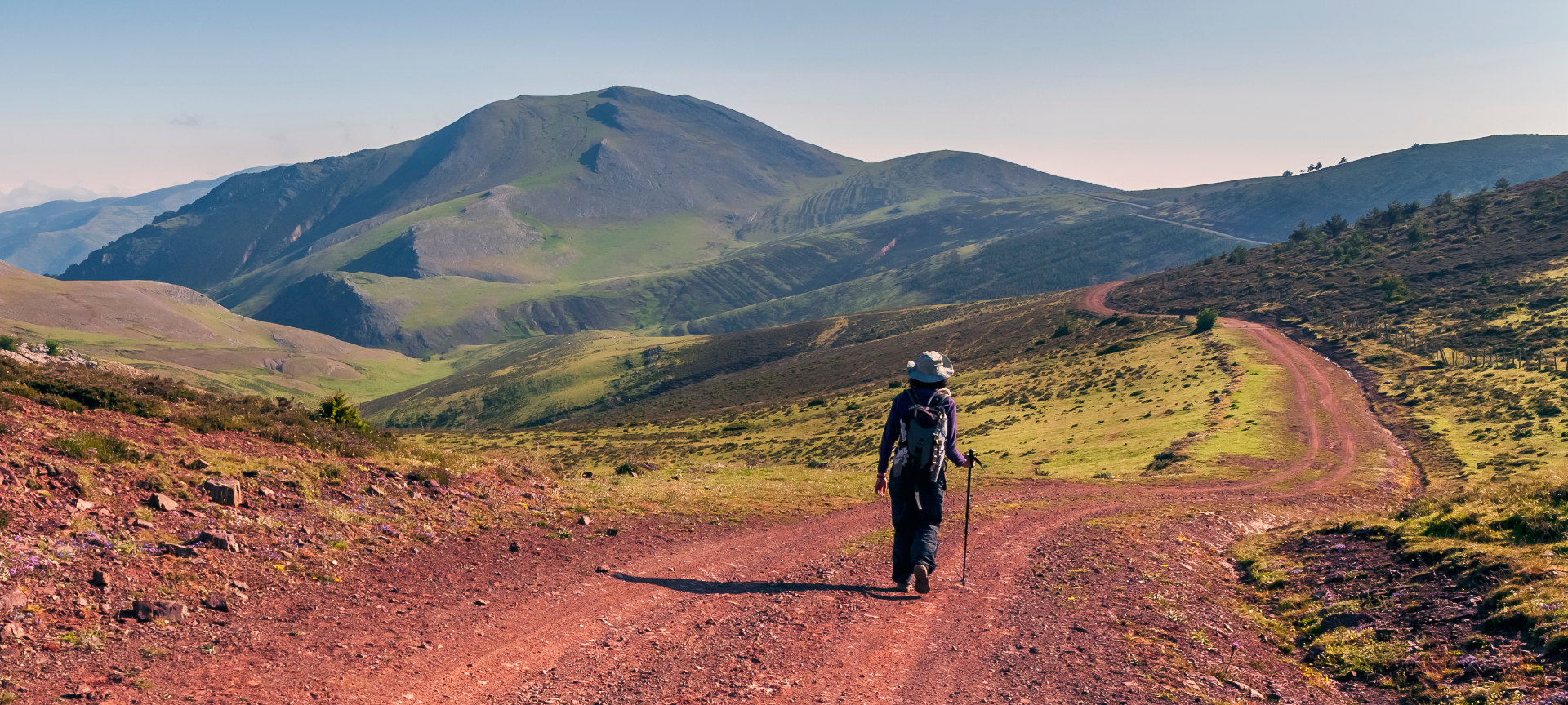 Hiker walking in the Sierra Cebollera mountain range on a sunny day, La Rioja