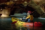 Un touriste pratique la spéléologie en kayak dans les Coves de Sant Josep de la Vall d