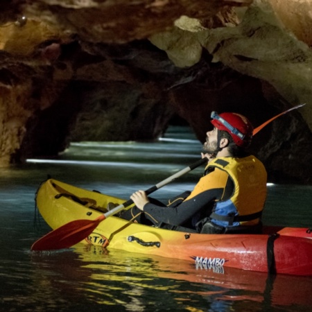 Turista praticando “espeleo-caiaque” nas cavernas de Sant Josep de La Vall d