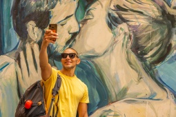 Tourist taking a selfie at a graffiti in Valencia, Region of Valencia