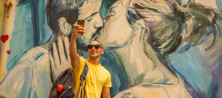 Touriste prenant un selfie devant un graffiti à Valence, Communauté valencienne Touriste prenant un selfie devant un graffiti à Valence, Communauté valencienne