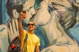 Tourist taking a selfie in front of a piece of graffiti in Valencia, Region of Valencia