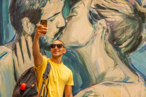 Tourist taking a selfie at a graffiti in Valencia, Region of Valencia