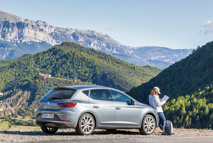 Tourist looking at a map near the Sierra Ferrera with the Peña Montañesa in the background, Huesca