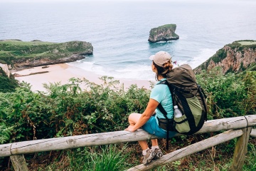  A pilgrim sitting with a view of the coast on the Northern Way of Saint James