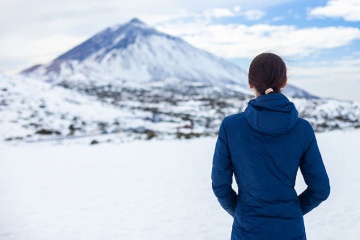 Ragazza che osserva il vulcano innevato del Teide